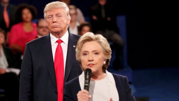 Republican US presidential nominee Donald Trump listens as Democratic nominee Hillary Clinton answers a question from the audience during their presidential town hall debate in Missouri on 9 October