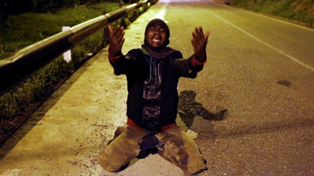 An African migrant reacts on a road after crossing the border fence between Morocco and Spain