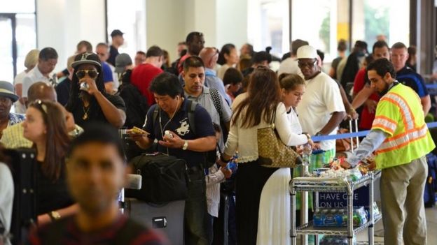 Delta offers refreshments as hundreds of passengers at Newark Liberty International Airport wait in line to check in for their flights (08 August 2016)