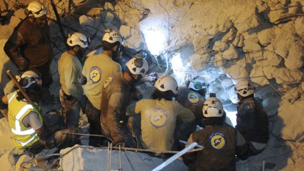 Syrian Civil Defence members, known as the White Helmets, search on June 6, 2016 for survivors amid the rubble of destroyed buildings