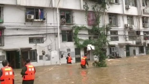 Rescue workers in a flooded street