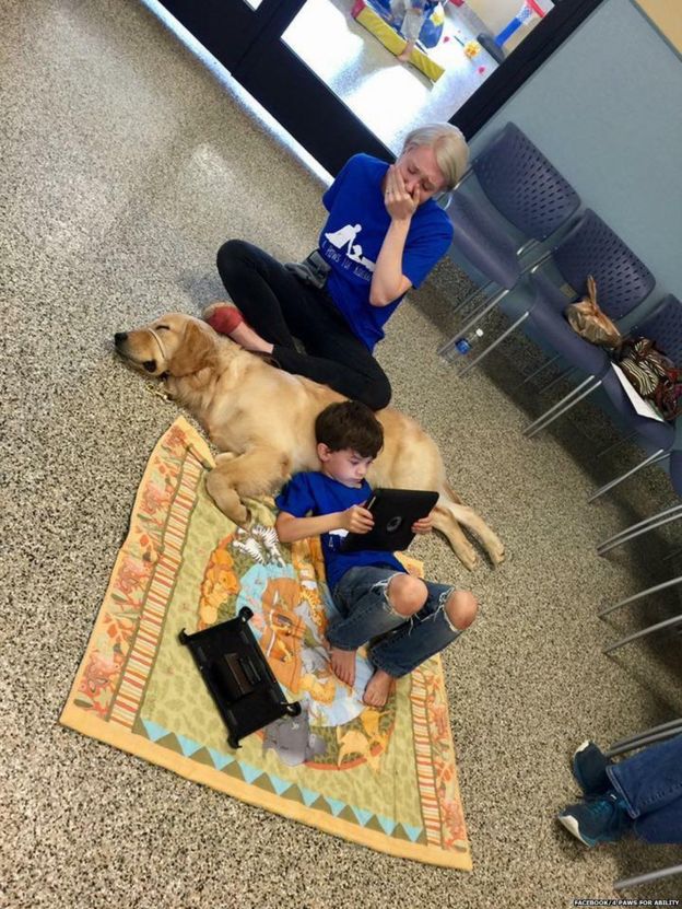 Madre de un niño con autismo lo ve recostado de un perro.