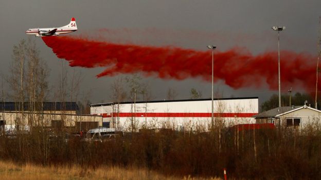 A plane drops fire retardant on the flames - 6 May