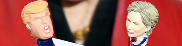 A public relations assistant holds up Donald Trump and Hillary Clinton pens during the 10th Annual