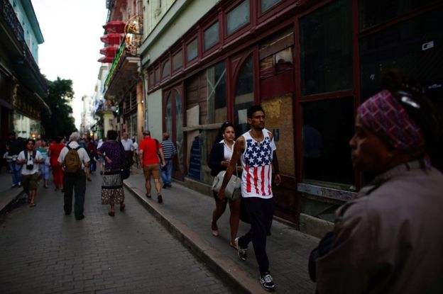 身穿美國星條旗文化衫的男子在古巴首都哈瓦那街頭走過。