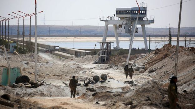 Members of the Syrian Democratic Forces (SDF) inspect a recaptured part of the Tabqa dam in northern Syria (27 March 2017)