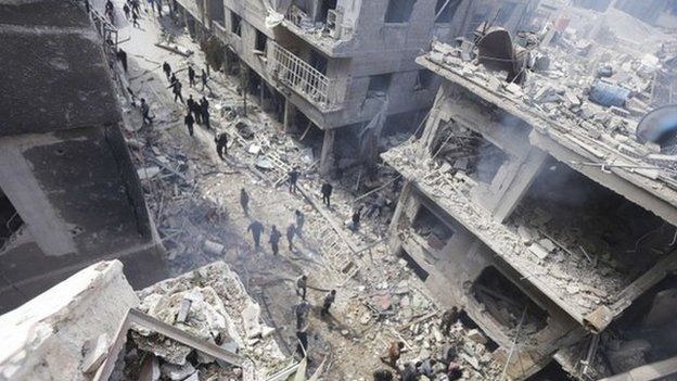 Pessoas inspecionar um local atingido por ativistas disseram que eram ataques aéreos por forças leais ao presidente da Síria, Bashar al-Assad no bairro de Douma de Damasco