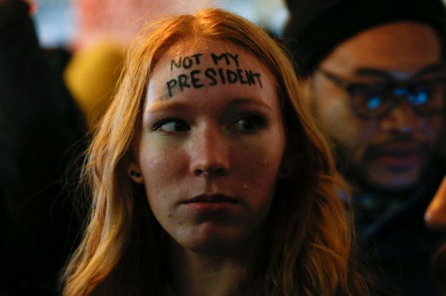 A woman looks on as she takes part in a protest against President-elect Donald Trump in front of Trump Tower in New York, 10 November