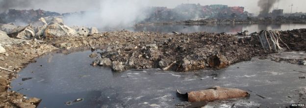 A pool of unknown liquid is seen as smoke rises from damaged shipping containers at Tianjin on 15 August 2015.