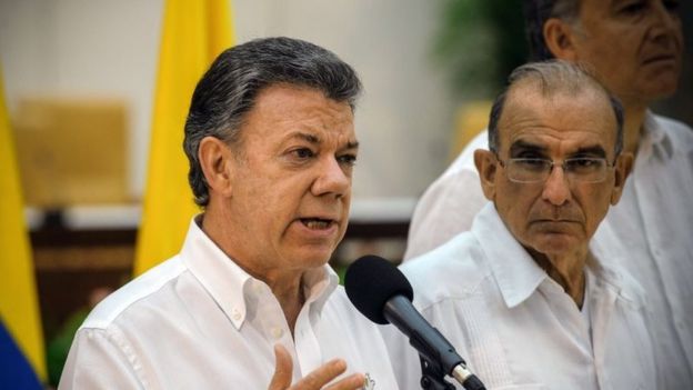 Colombian President Juan Manuel Santos speaks next to the head of the Colombian government delegation for the peace talks during a press conference in Havana on 23 September 2015