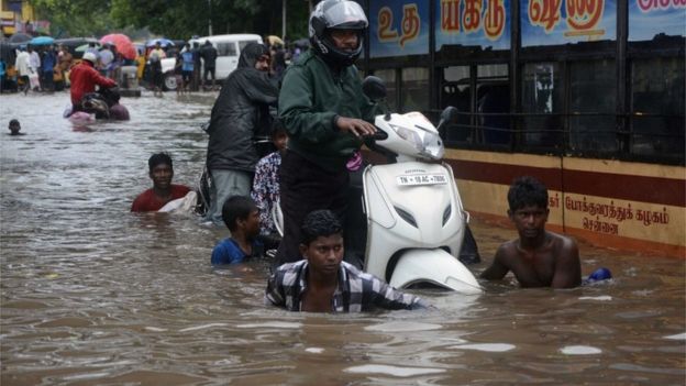 Indian men make their way on a flooded street in Chennai on November 9, 2015 following heavy rain from an approaching cyclonic system off the coast. Indian meteorological authorities have issue issued a cyclone alert for the Bay of Bengal coast in Tamil Nadu.