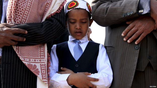 A boy takes part in morning prayers to celebrate the first day of the Muslim holiday of Eid-al-Fitr, marking the end of the holy month of Ramadan, in Ethiopia's capital Addis Ababa, 17 July 2015