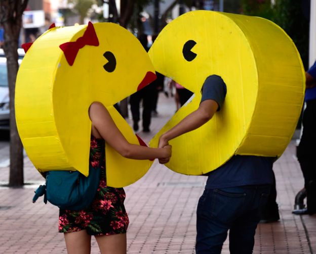 un hombre y una mujer disfrazados de Pac Man