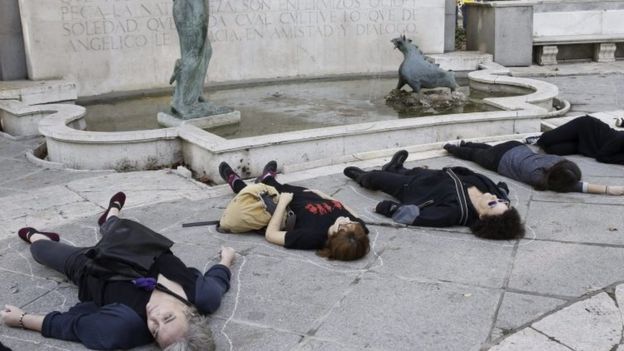 Women lie on the ground pretending to be dead during a march in Madrid. Photo: 7 November 2015