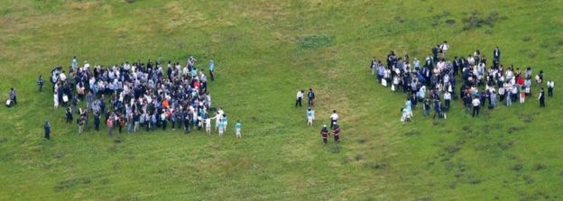 Passengers and crew by the side of the runway in Haneda airport, Japan (27 May 2016)