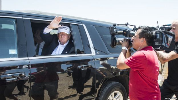 Republican presidential candidate Donald Trump waves from a limousine.