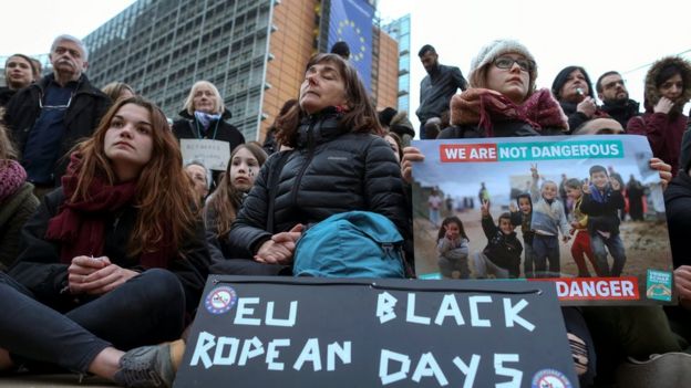 People take part in an event in solidarity with migrants in front of the European Council building in Brussels