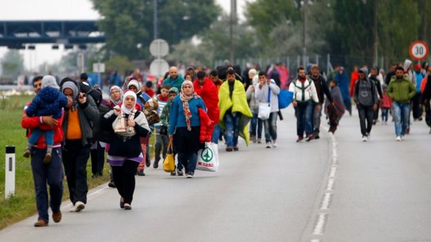 Migrants walk across the border at Nickelsdorf, Austria, 11 September 2011