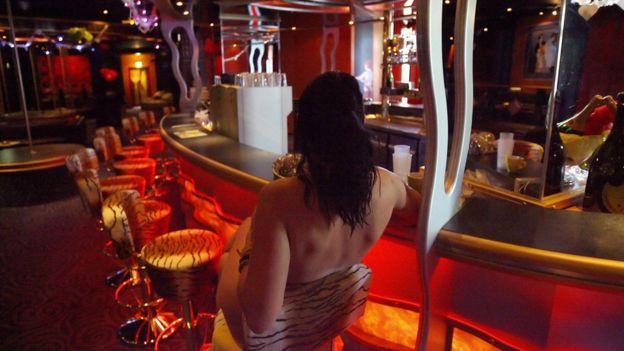 A sex worker poses at the bar of Berlin's Artemis brothel 04 May 2006
