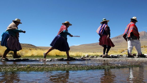 Indígenas aimaras caminan en las orillas del río Silala en el altiplano andino.