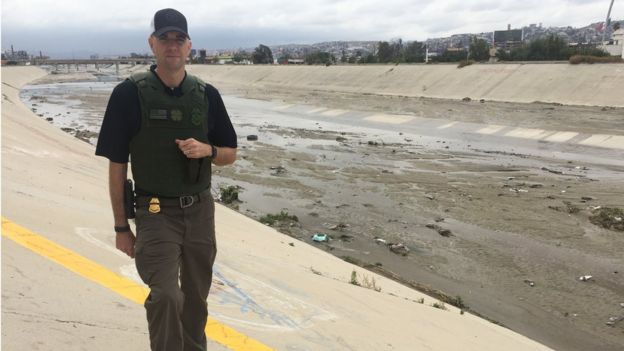 Border patrol agent Shawn Moran stands at the US-Mexico border