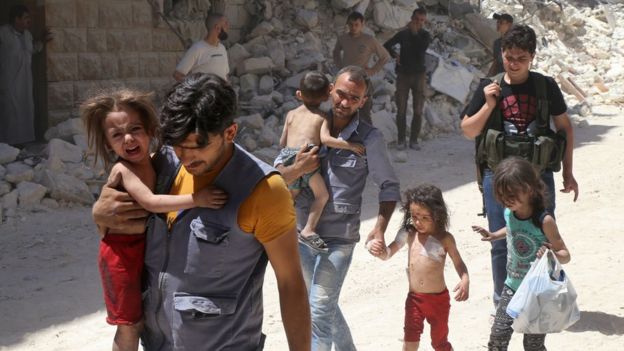 Men carry injured children after reported air strikes on the rebel-held district of Mashhad in the northern city of Aleppo, Syria, on 25 July 2016