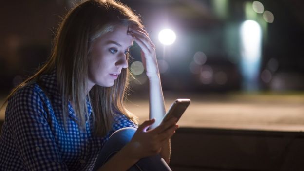 mujer preocupada mirando el celular