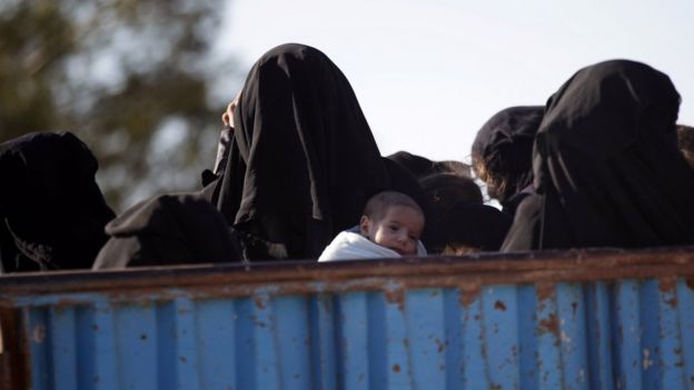 Una mujer huye con un niño de la ciudad de Al-Bab que controla EI desde 2014