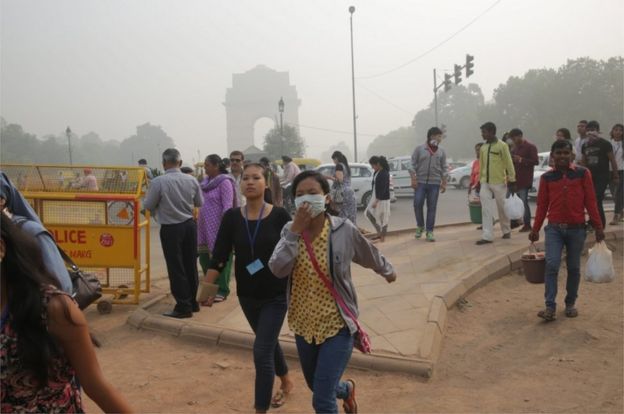 Indian people walk with masks on their faces near the India Gate in New Delhi, India, on 7 November 2016.