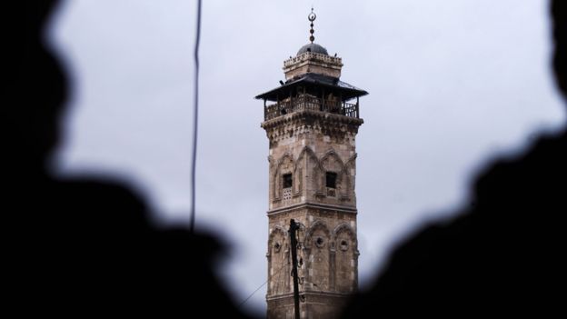 Aleppo minaret seen through two shadowy figures
