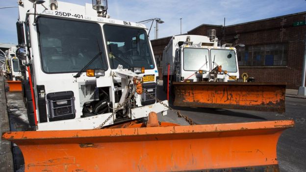 Snowploughs are mounted on sanitation trucks in the Brooklyn borough of New York. 13 March 2017