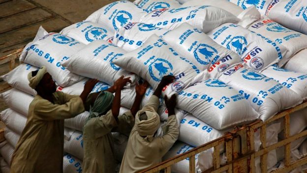 Sudanese workers offload US aid destined for South Sudan from the World Food Programme (WFP) at Port Sudan on March 19, 2017
