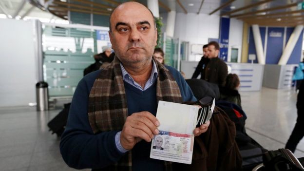 Fuad Sharef Suleman mostra seu passaporte à imprensa no aeroporto de Erbil, no Iraque