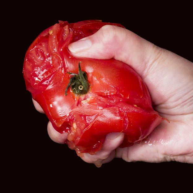 Mujer espichando un tomate