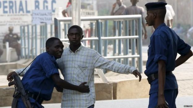 Police search a man arriving at a voting station in Bujumbura during the country's presidential elections (21 July 20915)