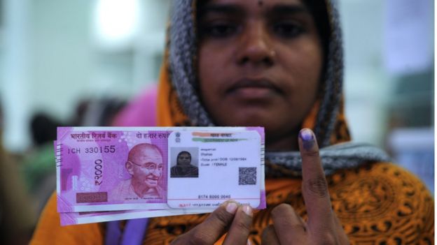 Persona con billete y documento de identidad.