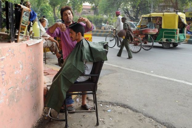 An Indian gets his hair cut at a roadside barber shop in New Delhi