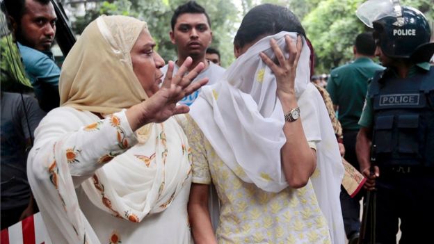 A relative tries to console Semin Rahman, covering face, whose son is missing after militants took hostages in a restaurant popular with foreigners in Dhaka, Bangladesh, Saturday, July 2, 2016
