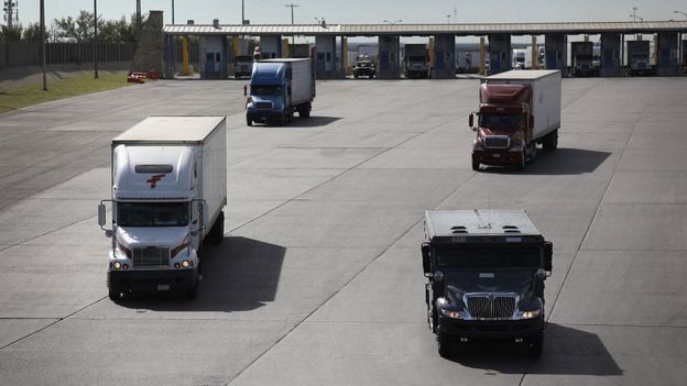 Camiones de carga cruzan la frontera entre México y Estados Unidos.
