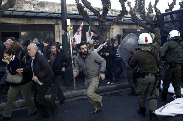 Protesters of the Communist-affiliated trade union PAME run as they try to break through a police formation during a rally against the pension reform system, outside the parliament, in Athens, Greece, 8 January 2016