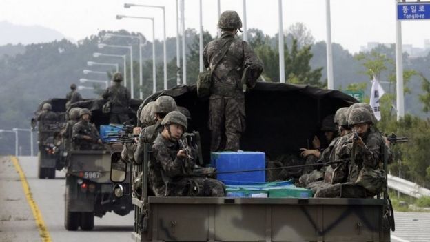 South Korean army soldiers ride on trucks in Paju, south of the demilitarized zone that divides the two Koreas, South Korea, Monday, Aug. 24, 2015.