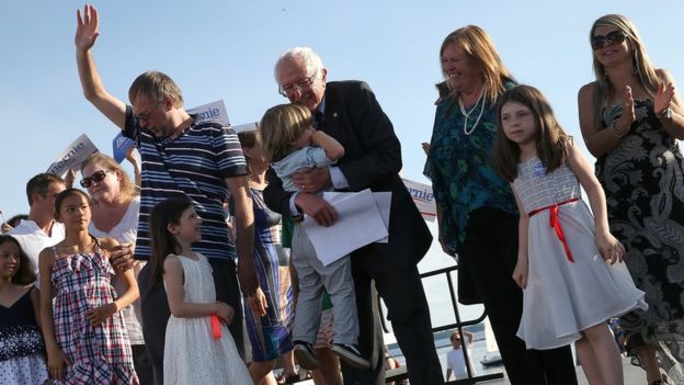 Sanders hugs one of his grandchildren onstage