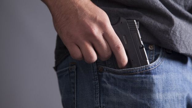 Person concealing gun in pocket