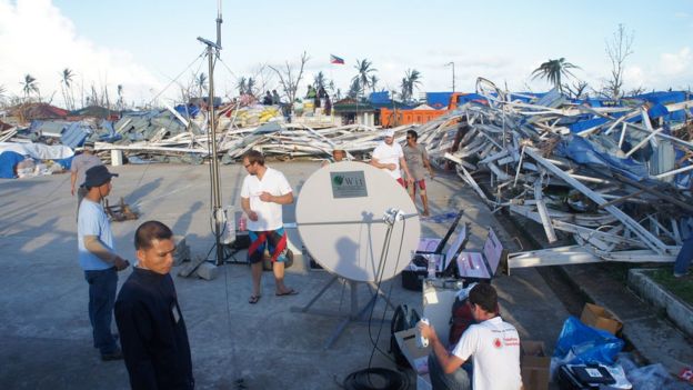 Setting network mast amid typhoon destruction