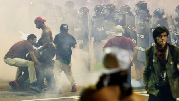 People manoeuvre amongst tear gas in Charlotte, North Carolina during a protest on 21 September