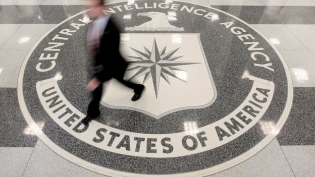 Un hombre camina encima de un logo de la CIA