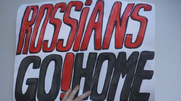 A demonstrator holds a placard during an opposition rally in Minsk against the deployment of Russian military bases in Belarus (04 October 2015)