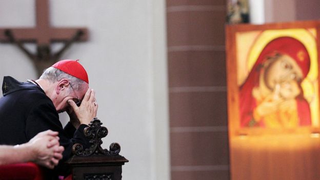 El cardenal Joachim Meisner, arrodillado y rezando.