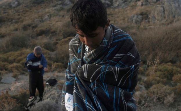 An Afghan migrant is covered with a blanket moments after his arrival on an overloaded rubber dinghy, on the island of Lesvos, having crossed the Aegean sea from Turkey, Greece, 10 October 2015.