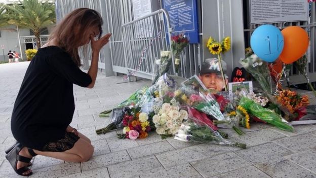Una mujer llora frente al homenaje en Marlins Park.